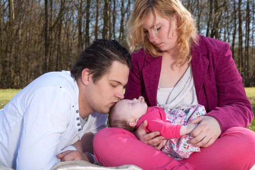 Young family is having  nice time with their baby on a sunny day