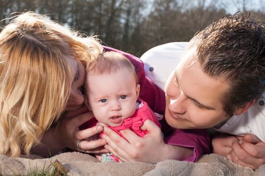 Young family is having  nice time with their baby on a sunny day