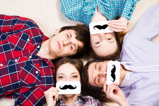 four young men lie together, applied to the face plate with a mustache