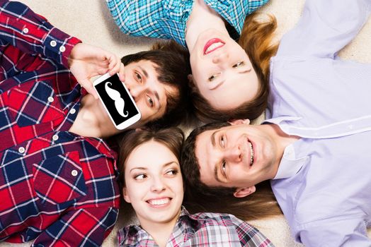 four young people are together, the young man pressed his lips to the phone