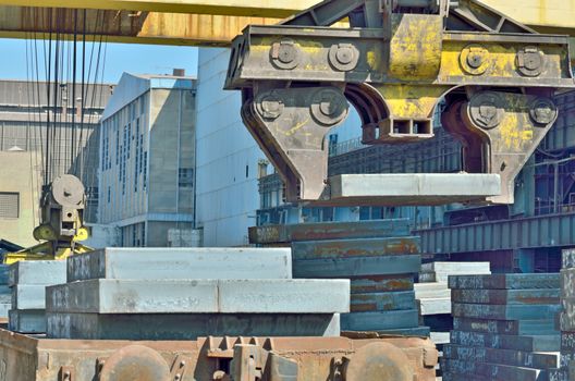 Crane loading sheet steel in plant