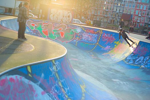 AMSTERDAM, THE NETHERLANDS ��� FEBRUARY 24, 2014: Local skaters are training on a skate ground in Amsterdam on a warm winter day. Residential districts are well equipped for sport activities there.