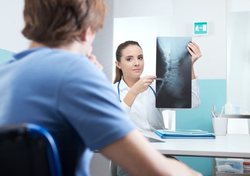 Young patient with female doctor discussing x-ray