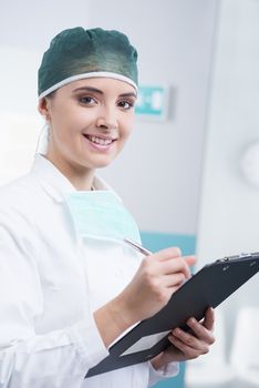 Young woman surgeon in office with clipboard