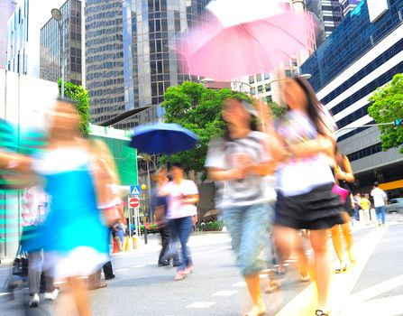 Unidentified women with umbrellas crossing the street in Singapore