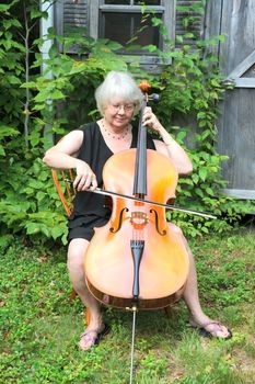 Female cellist performing a classical piece outside.