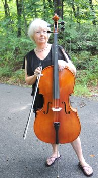 Female cellist performing a classical piece outside.