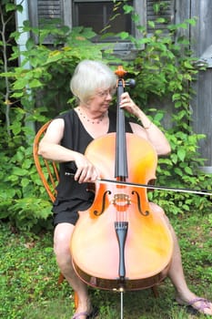 Female cellist performing a classical piece outside.