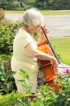 Female cellist performing a classical piece outside.