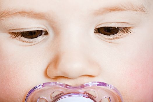 sad face baby with pacifier closeup. macro