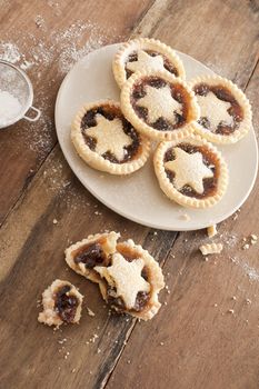 Eating tasty home baked Christmas mince pies freshly baked in a rustic kitchen and decorated with pastry stars