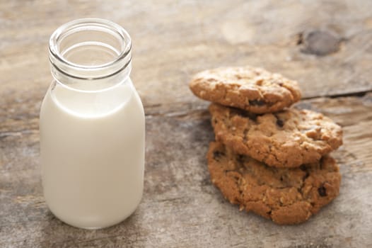 Childhood treat of a glass bottle of fresh milk served with crunchy cookies for a delicious snack