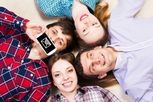 four young people are together, the young man pressed his lips to the phone