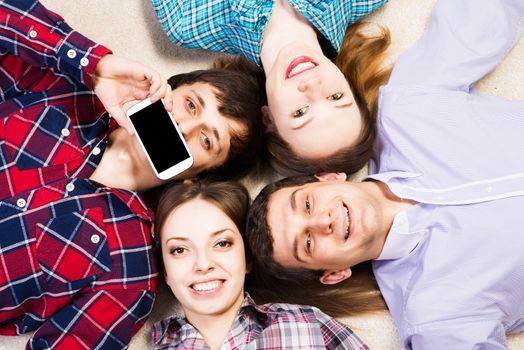 four young people are together, the young man pressed his lips to the phone