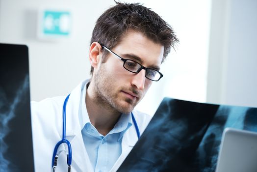 Professional radiologist examining an X-ray image of human spine.