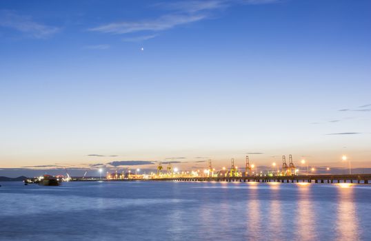 Commercial docks at sunset with ship and cranes