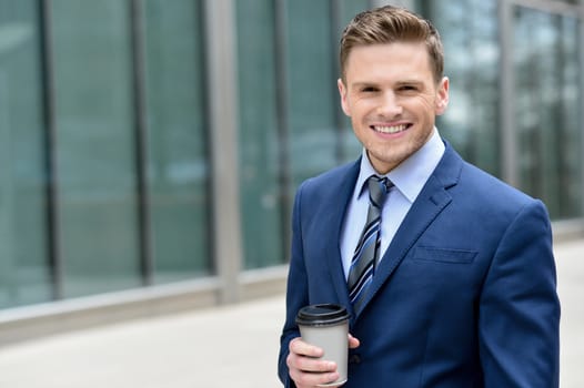 Businessman with a cup of a coffee, outdoors