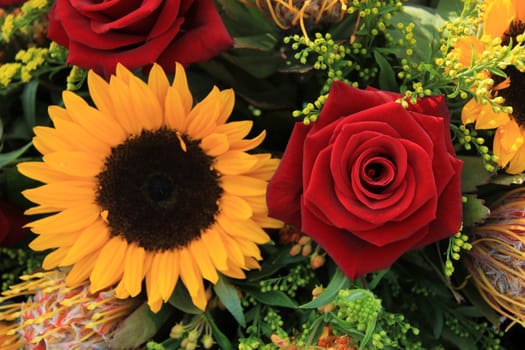 Sunflowers and big red roses in a wedding arrangement