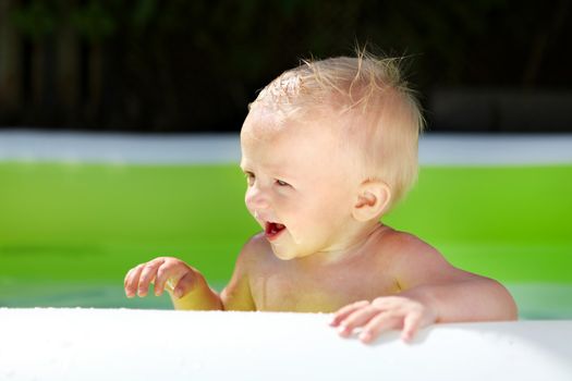 Playful Baby Boy in the Pool at Sunny Summer Day