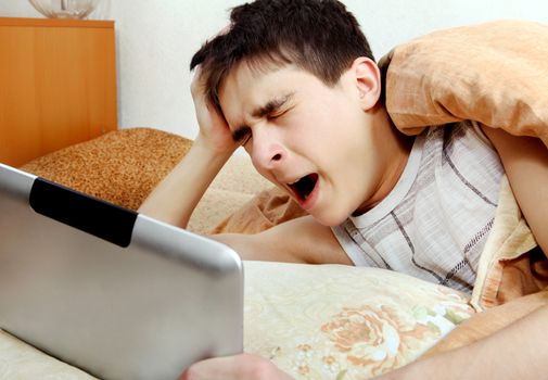 Tired Teenager Yawning with Tablet Computer at the Home