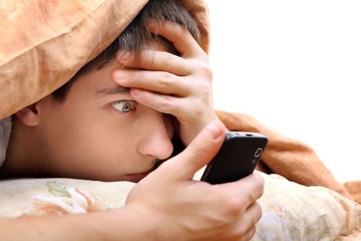 Frightened Teenager with Cellphone under Blanket at the Home