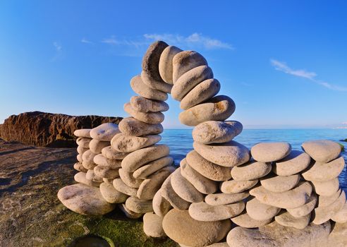 Bend of pebbles between of the stones on the coast