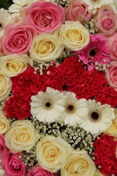 pink and white roses, together with carnations and gerberas in a wedding centerpiece