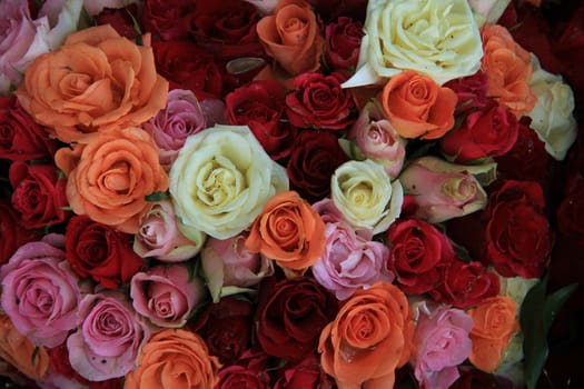 Variation of orange, red and pink roses in a wedding flower arrangement