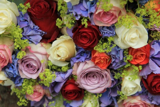Roses in various colors on a blue hydrangea background, bridal arrangement