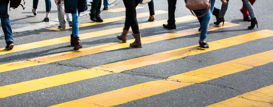 urban traffic concept - city street with a motion blurred crowd crossing a road