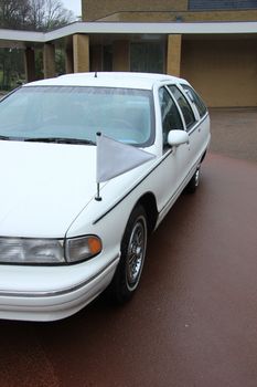 White hearse, funeral service car, on a cemetary