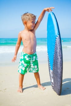 Boy has fun on the surfboard in transparency sea