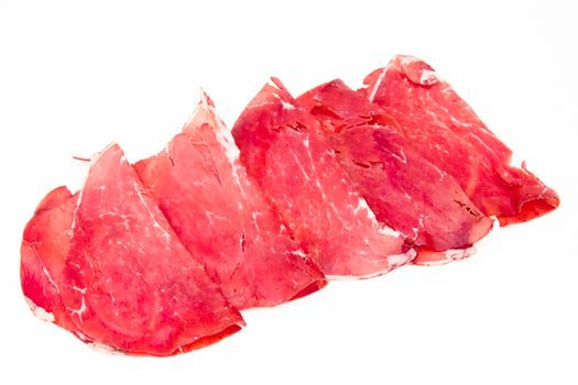 Slices of dried beef on white background