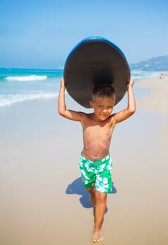 Boy has fun on the surfboard in transparency sea