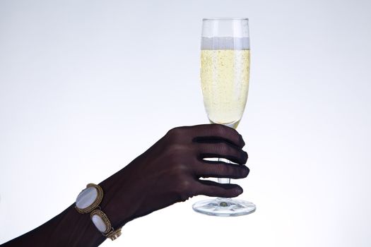 Close-up shot of female hand in black opera glove holding champagne glass, studio shot 
