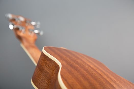 Close-up shot of classic ukulele guitar, back view, selective focus  