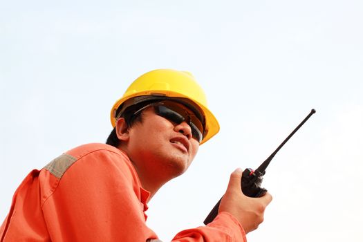 isolated white background. young man communicating on walkie-talkie at site