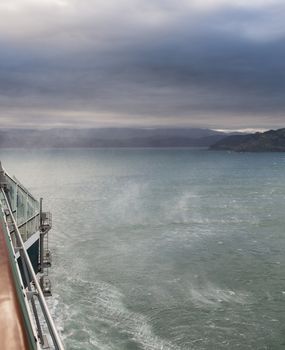 Sea in Wellington bay in New Zealand on cloudy stormy day as the fierce wind whips up the spray off the ocean