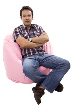 young casual man seated in a small sofa