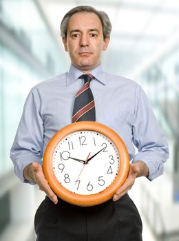 mature handsome business man holding a clock