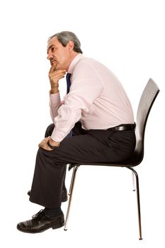 worried mature businessman on a chair, isolated on white