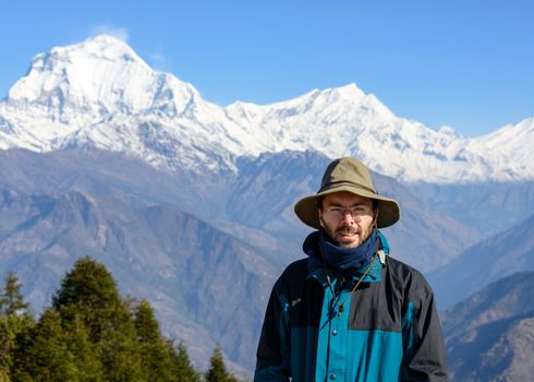 Young man wearing a hat, Dhaulagiri massif in the background, Nepal