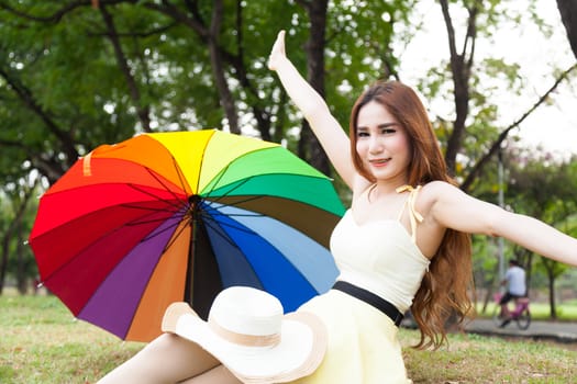 Woman sitting on the grass in the park. Posture relaxed and happy.