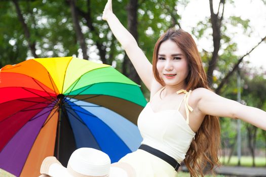 Woman sitting on the grass in the park. Posture relaxed and happy.