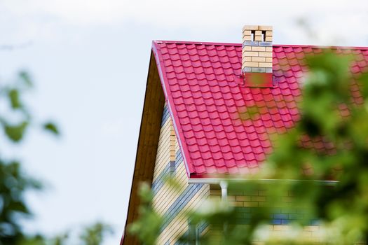 Red roof brick house on a background of the summer sky