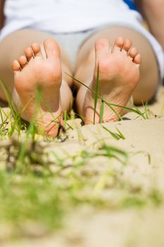 children's feet on a sandy beach in summer