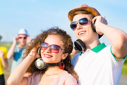 young couple standing on the road, having fun with friends