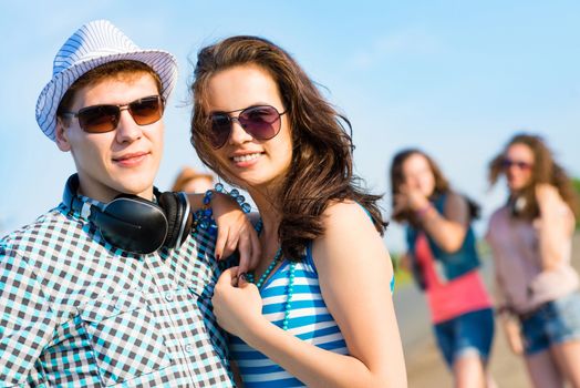 young couple standing on the road, having fun with friends