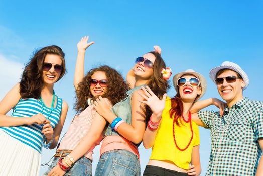 group of young people wearing sunglasses and hats hugging and standing in a row, spending time with friends