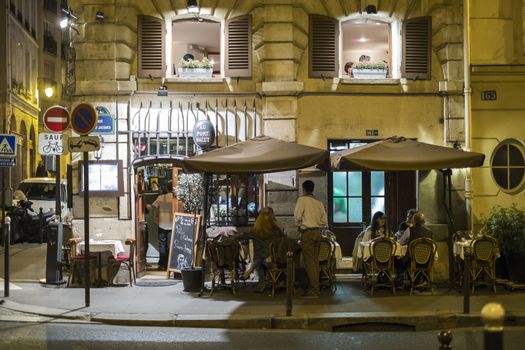 Paris, FRANCE - OCTOBER 19: Night shot of restaurant Au Port Salut with people dining outside. October 19, 2013 in Paris.